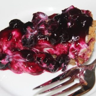 Blueberry cheesecake pie on a white plate with a fork