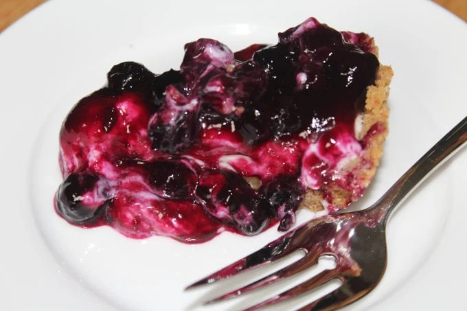 Blueberry cheesecake pie on a white plate with a fork