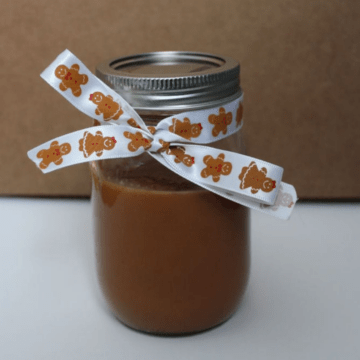 Cajeta sauce in a mason jar with a ribbon tied around it.