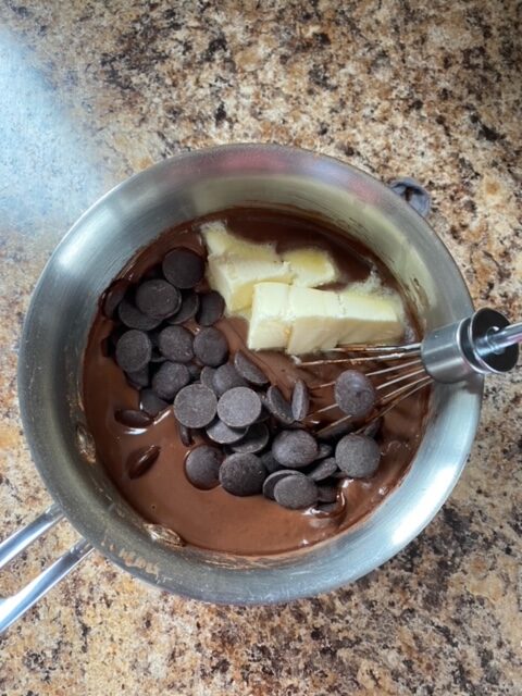 Chocolate, butter, and vanilla extract added to the sauce pan.
