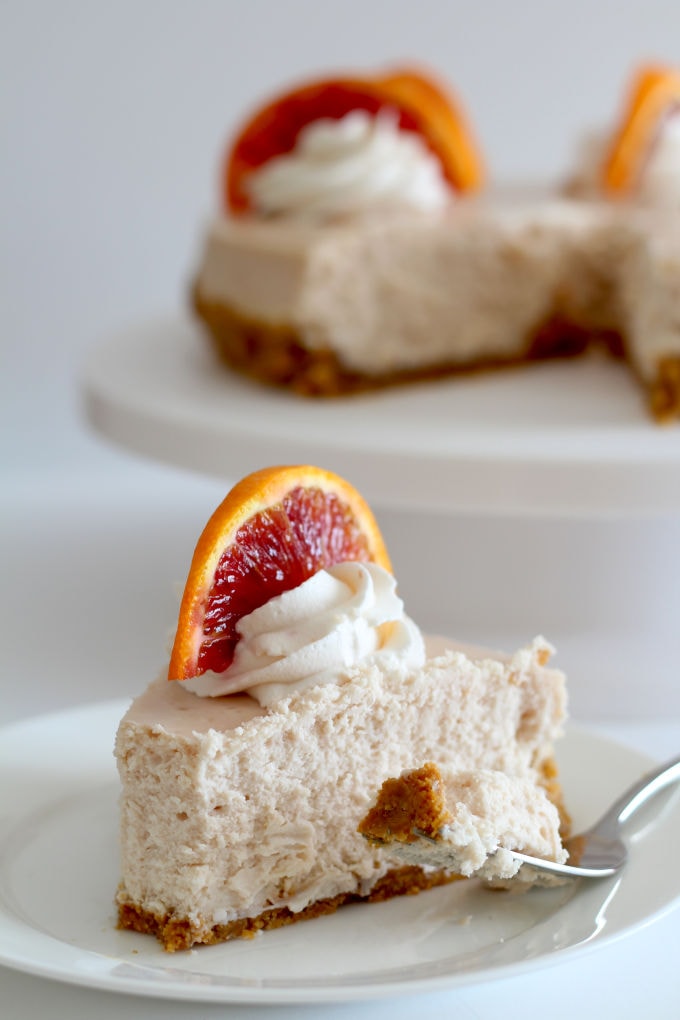 Blood Orange Cheesecake decorated with whipped cream and slices of blood oranges.