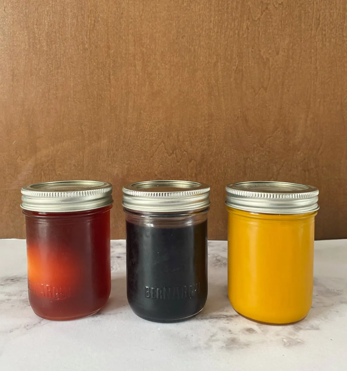 Three mason jars with natural egg dyes in each one.  