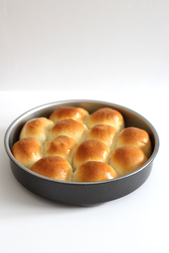 A round pan filled with dinner rolls.