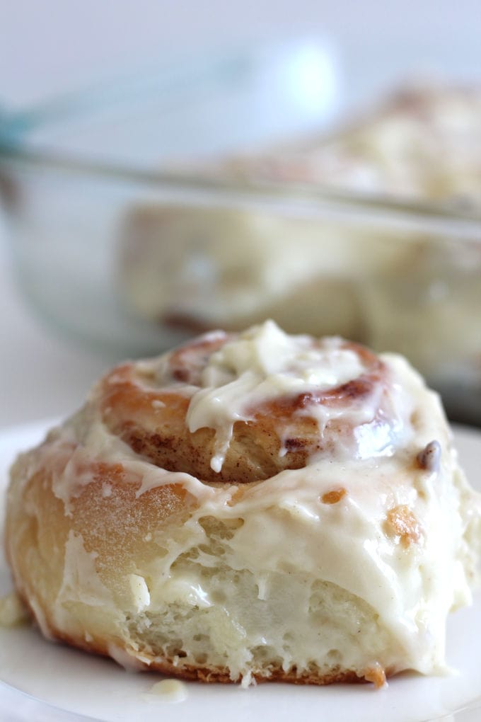 A cinnamon roll with cream cheese frosting on a plate