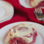 A red velvet cinnamon roll on a plate.