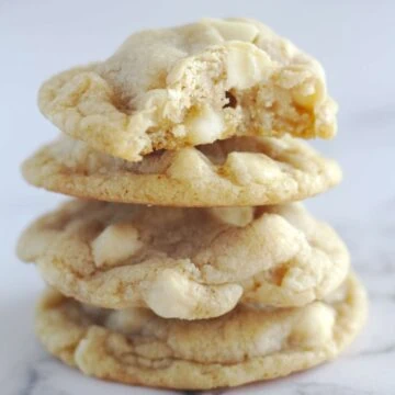 Four cookies stacked on top of each other. The top cookie has a bite taken from it.