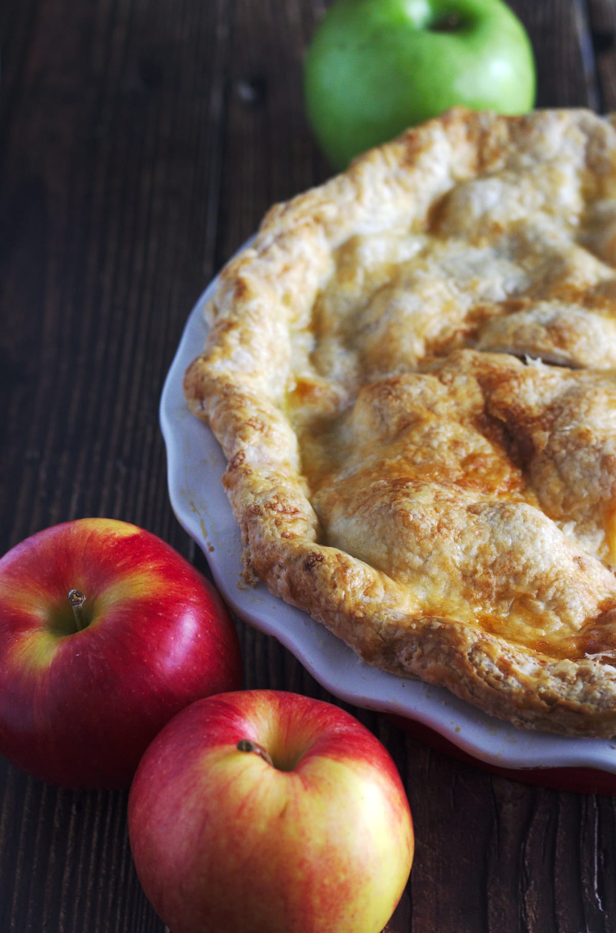 A pie with apples around it.