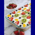 A cake in a casserole dish with strawberries around it.