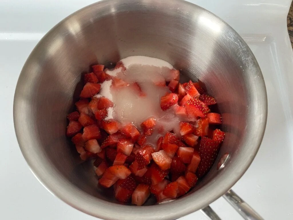 Strawberries, sugar and lemon juice in a saucepan.