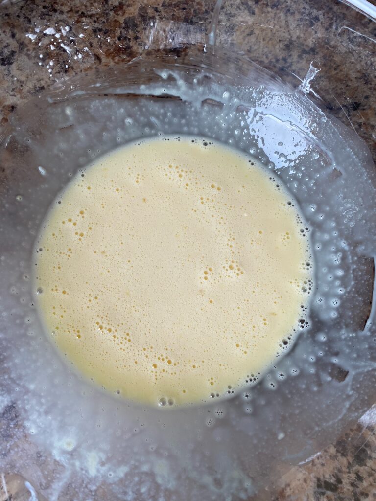 A bit of milk mixture whisked into egg mixture to temper the eggs.