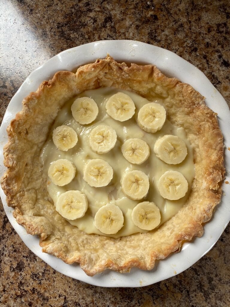 A bit of pudding in the bottom of the pie crust with sliced bananas on top.