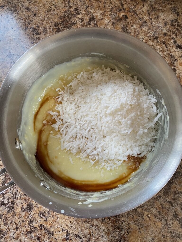 coconut and vanilla extract with pudding in a saucepan.