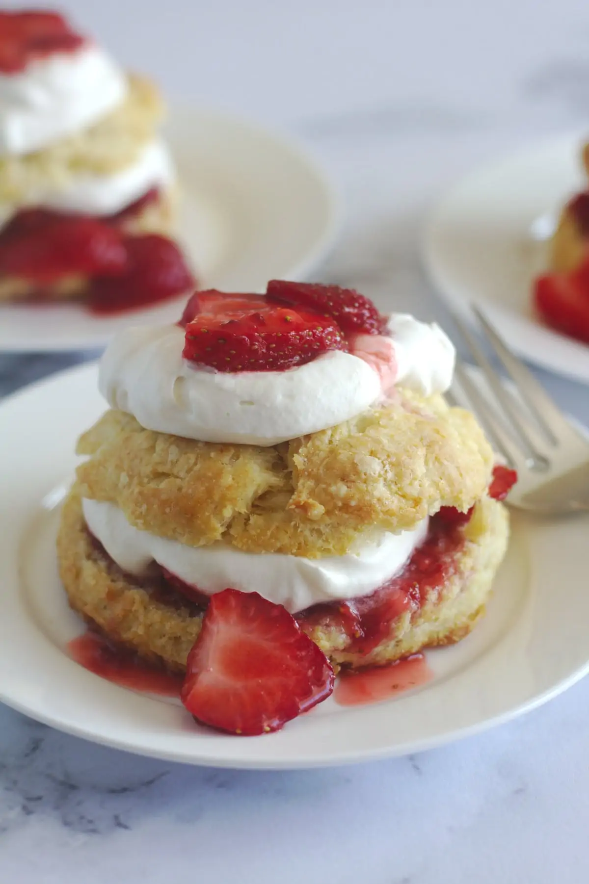 A strawberry shortcake on a plate with a fork.  