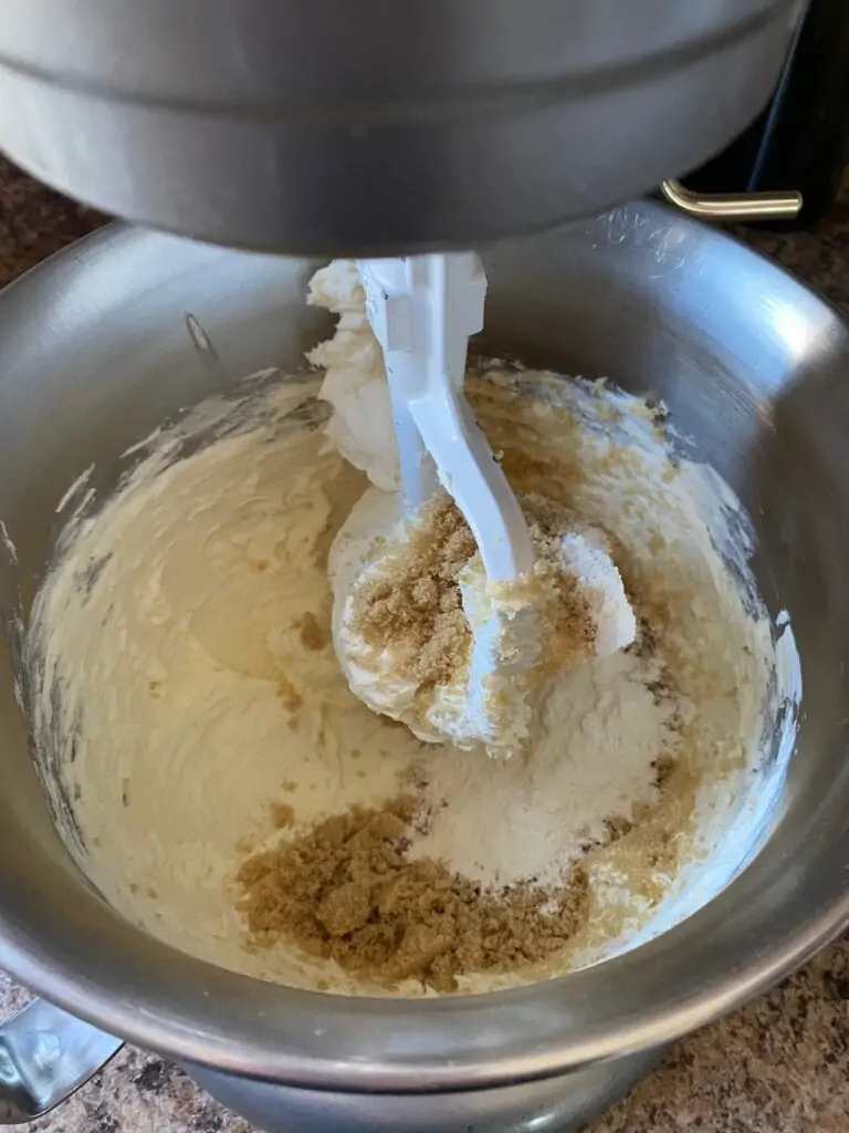 Cream cheese and brown sugar being mixed together.