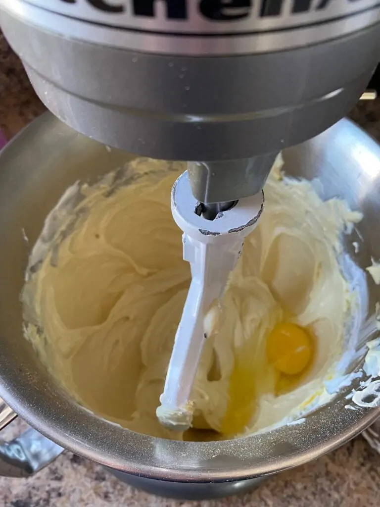 Eggs being added to the mixing bowl, one at a time.
