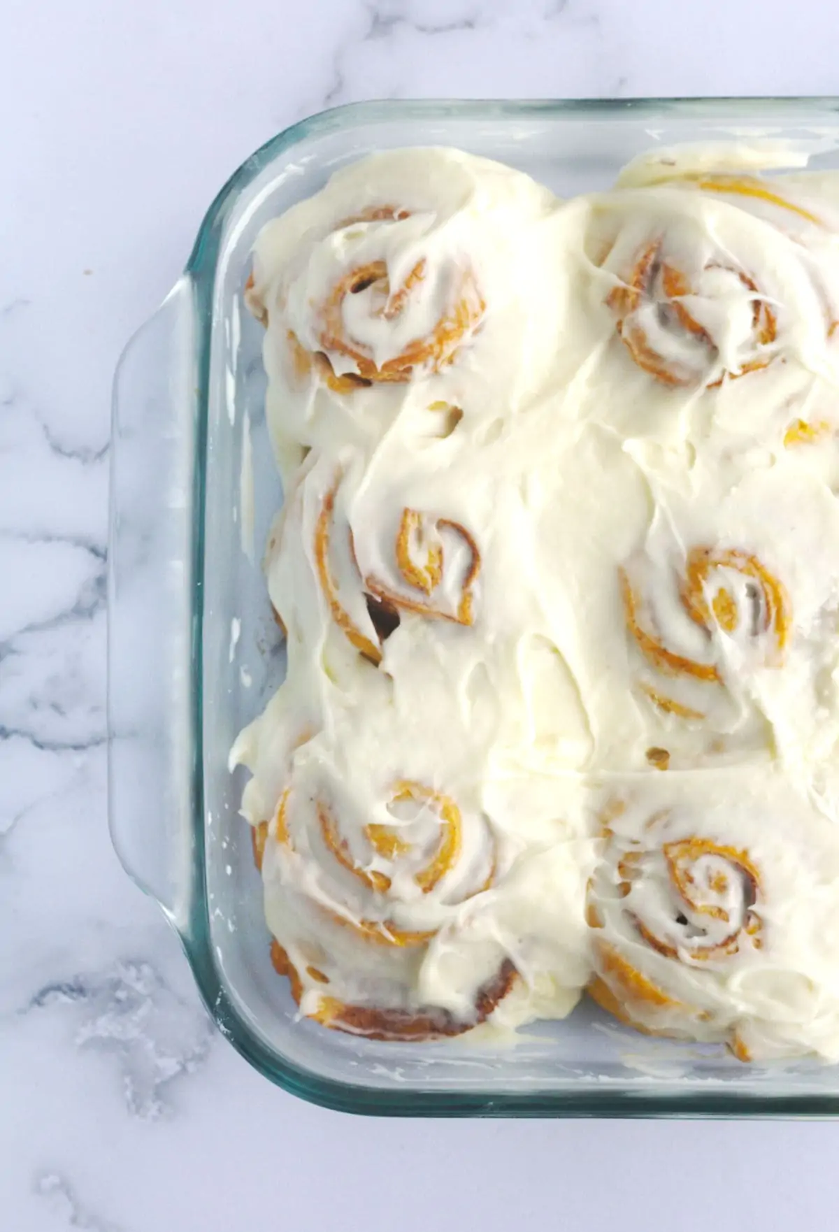 A baking dish with cinnamon rolls in it.