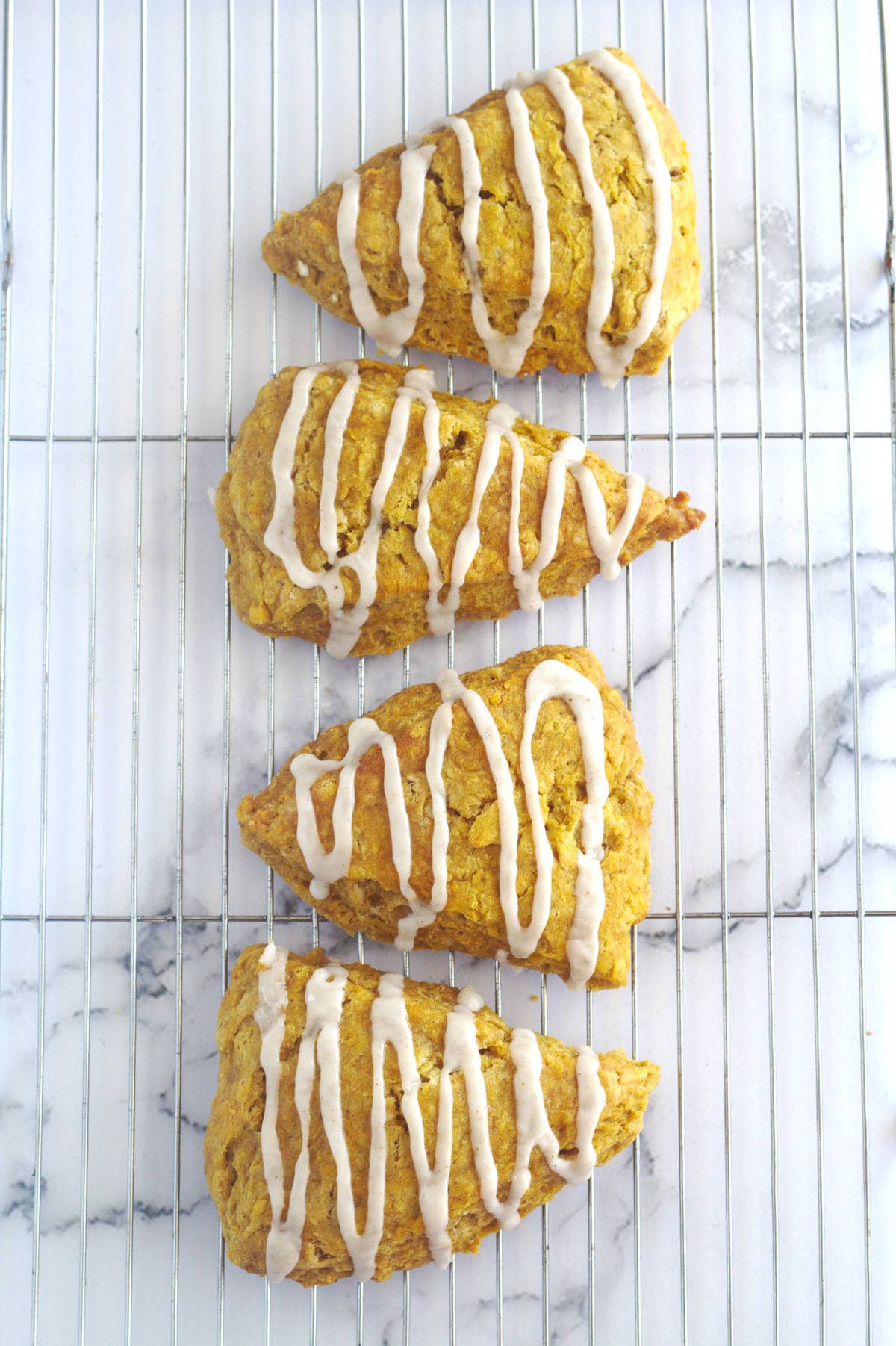 Four scones on a wire rack.
