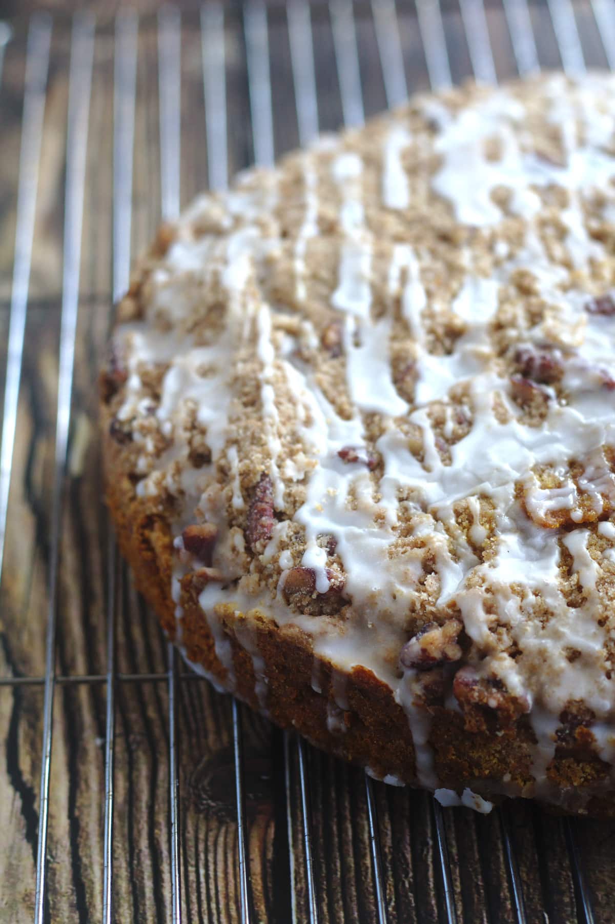 An iced coffee cake on a wire rack.