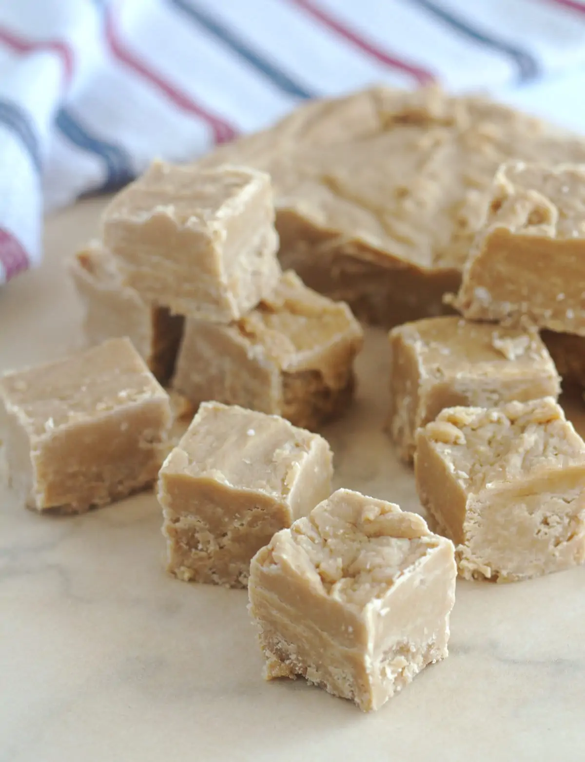 Squares of fudge scattered across a piece of parchment paper.
