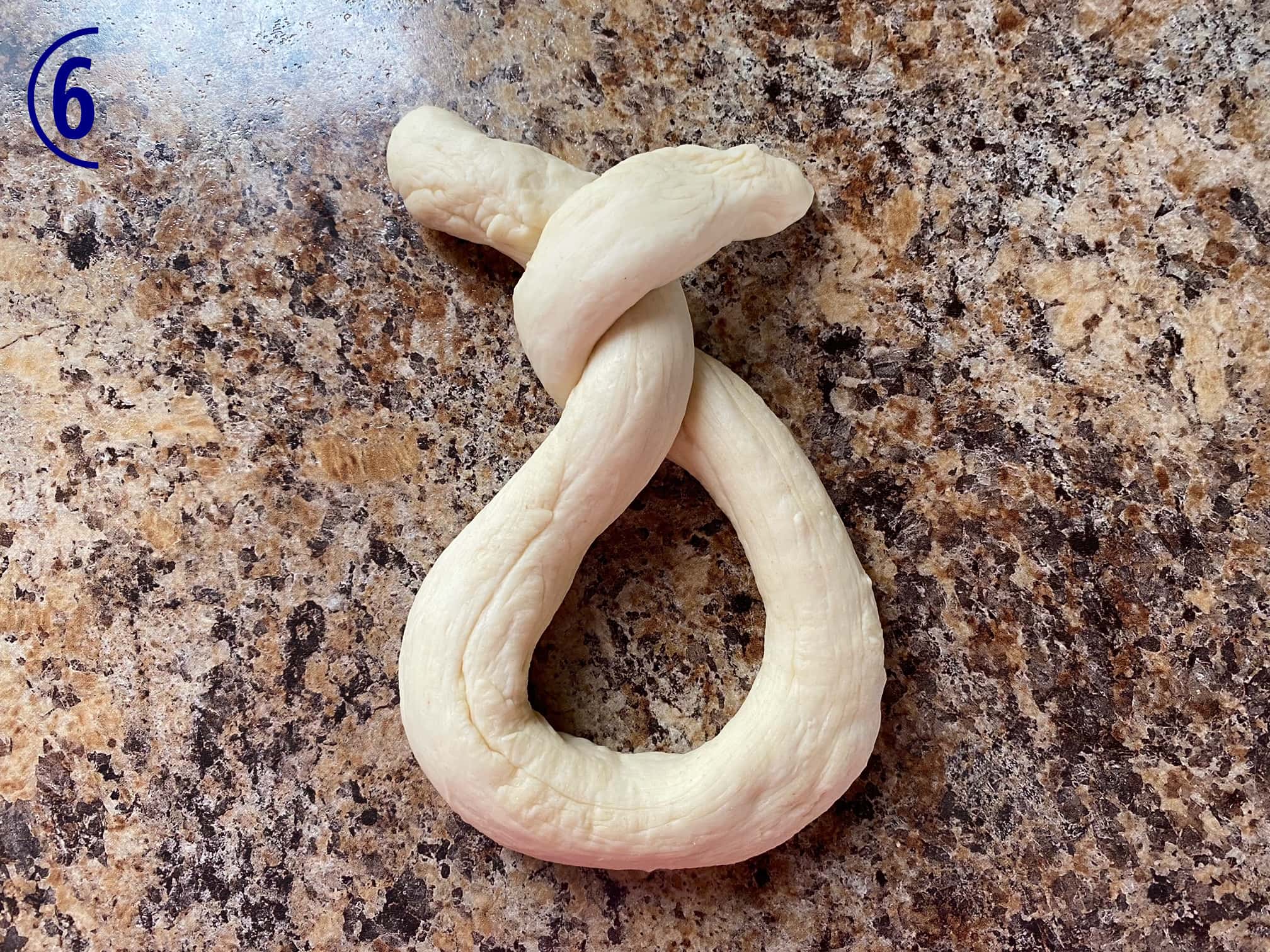 Dough rope has ends crossed twice.