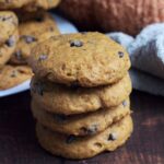 Cookies stacked on top of each other. More cookies are in the background on a plate.