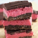 Three Nanaimo bars stacked on top of each other.