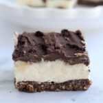 A single Nanaimo bar with more in the background.