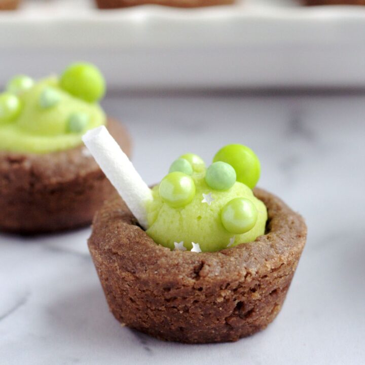 A cookie cup with sprinkles on it, and a popeye candy stick sticking out of it.