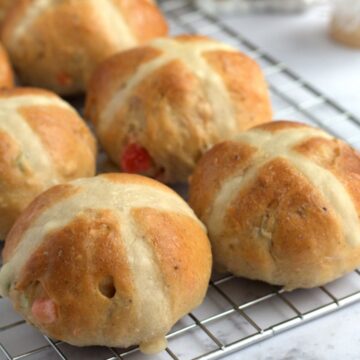 Hot cross buns on a wire rack.