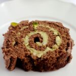 A slice of yule log on a white plate.