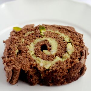 A slice of yule log on a white plate.