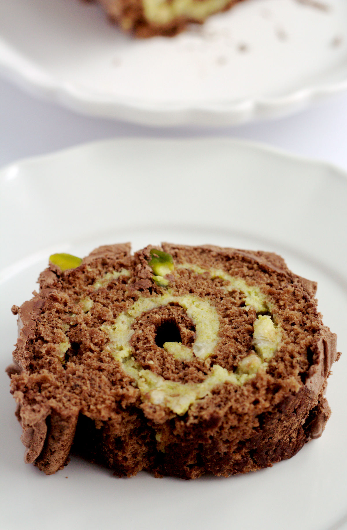 A slice of yule log on a white plate.