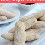 A bunch of ladyfinger cookies on a white platter.